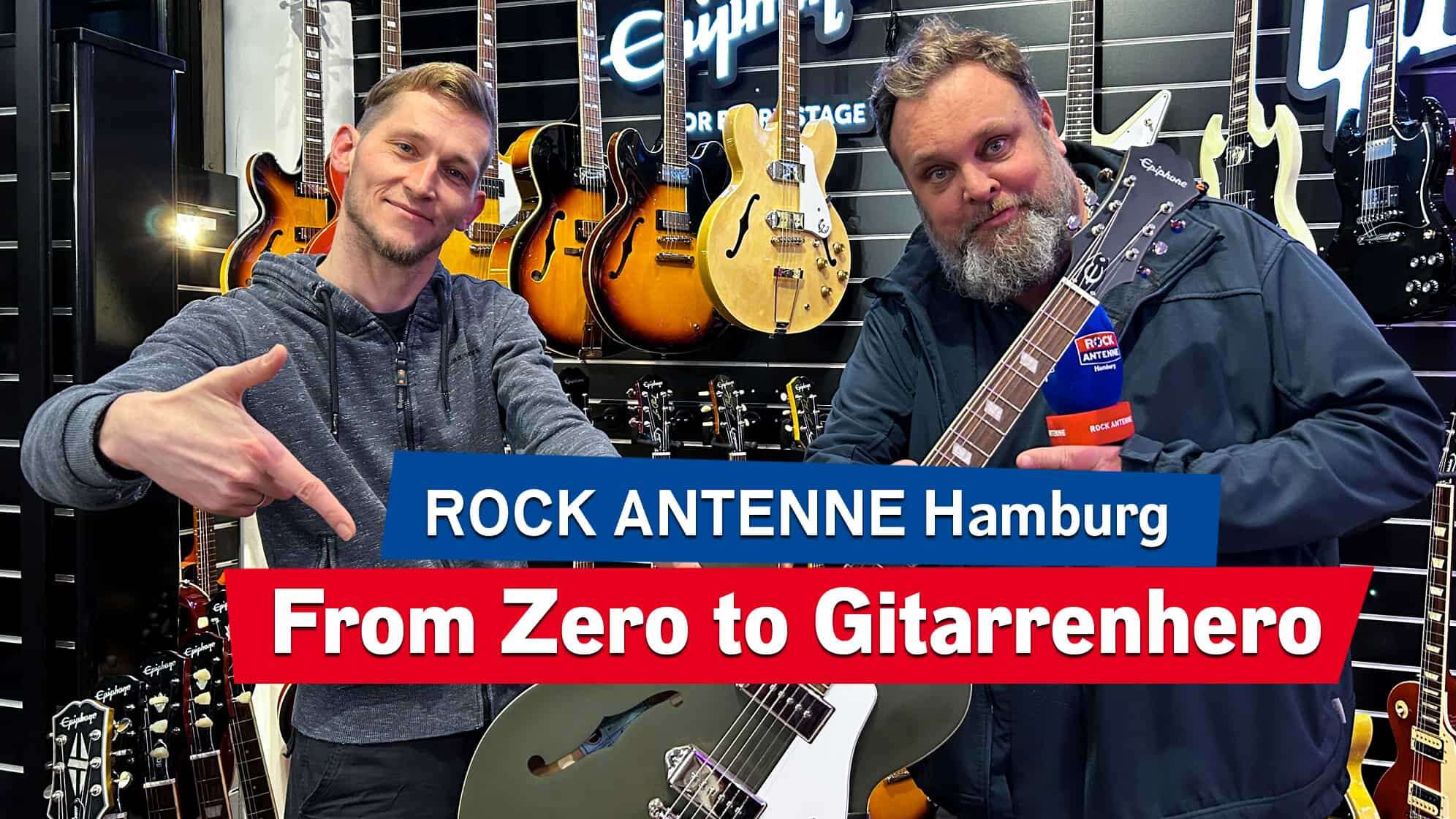 Nils von No.1 Guitar Center in Hamburg mit Morgenmoderator Alex Schmidt im Gitarrengeschäft, im Hintergrund hängen Gitarren an der Wand, die beiden halten eine in die Kamera und lächeln, dazu der Text: ROCK ANTENNE Hamburg From Zero to Gitarrenhero