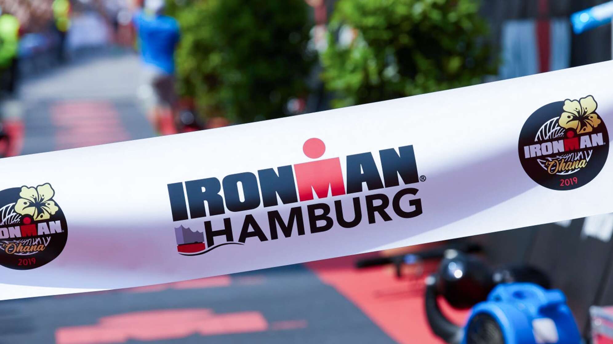 Ein Banner vor einer Laufstrecke mit der Aufschrift "IRONMAN Hamburg"
