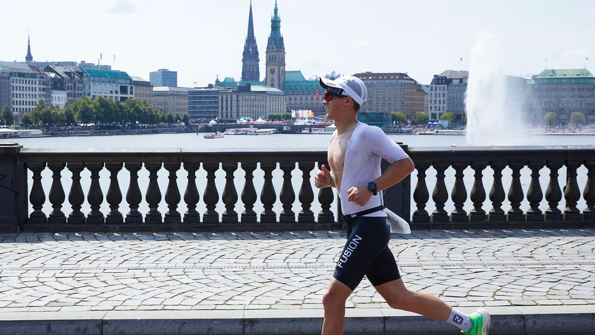 Triathlon: Ironman World Series/Deutsche Meisterschaft, Männer: Kristian Hogenhaug aus Dänemark läuft über die Lombardsbrücke. Im Hintergrund sind die Binnenalster und das Rathaus zu sehen.