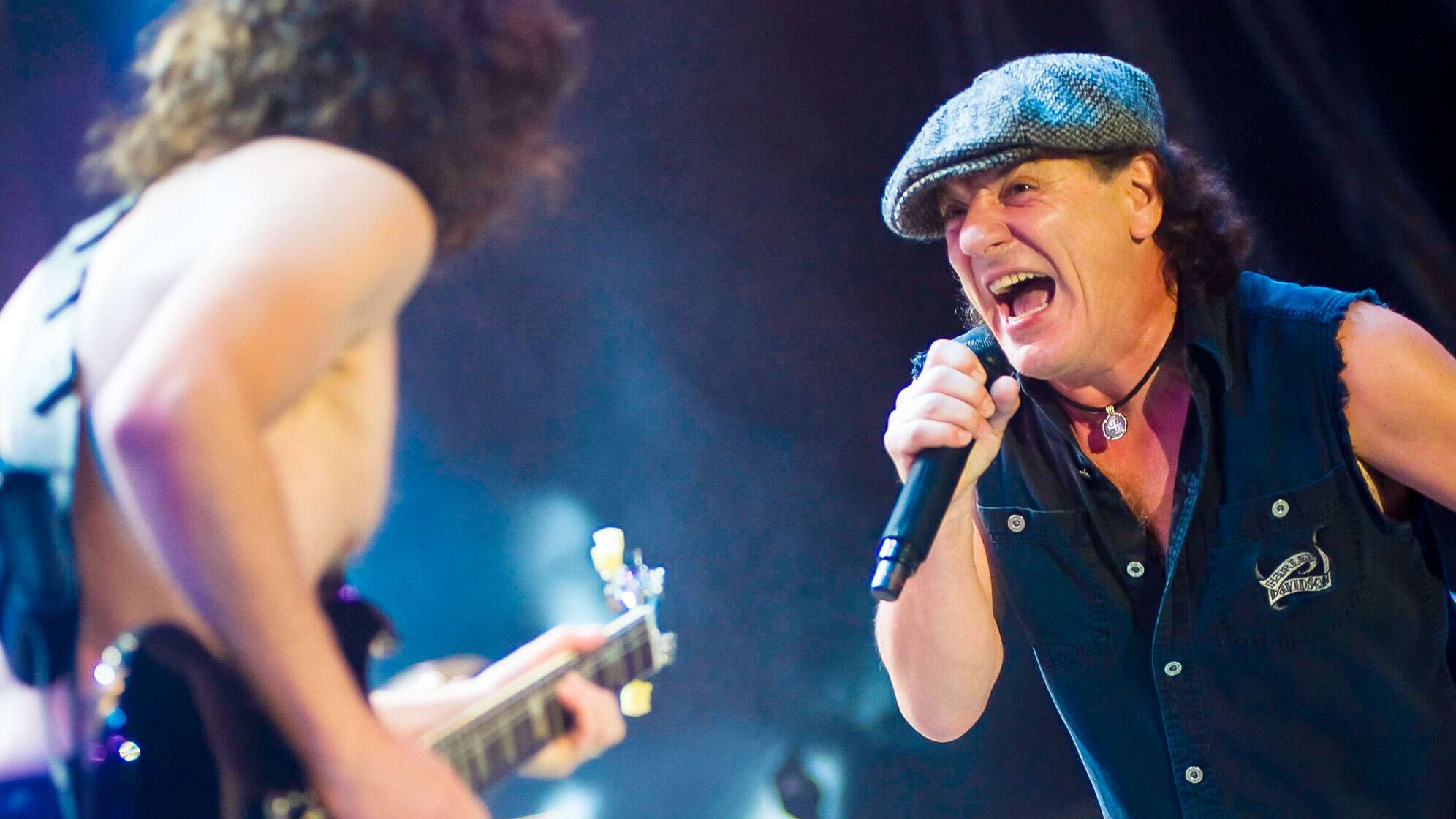 Angus Young und Brian Johnson stehen bei einem AC/DC-Konzert gemeinsam auf der Bühne.