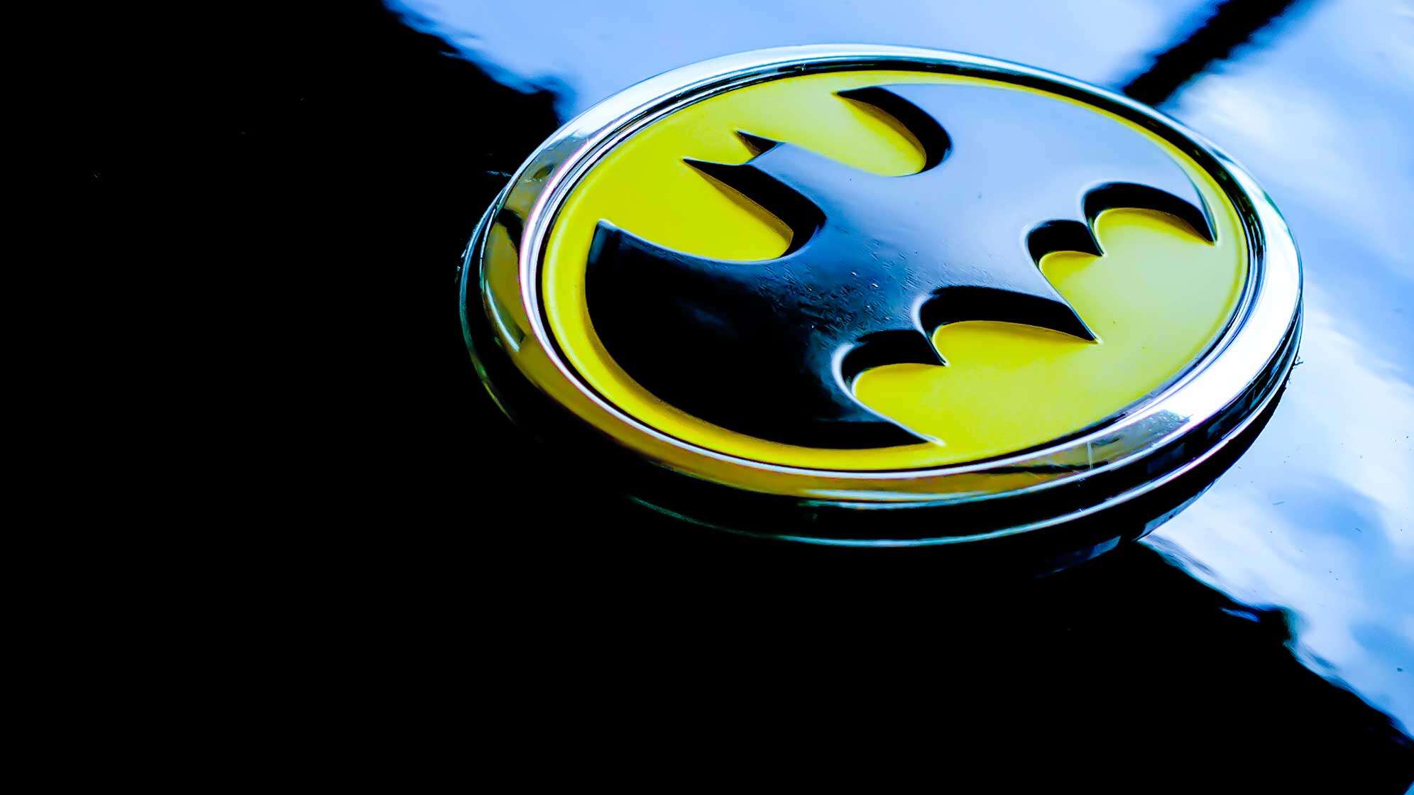 Das Batman-Logo auf einem schwarz glänzendem Hintergrund.