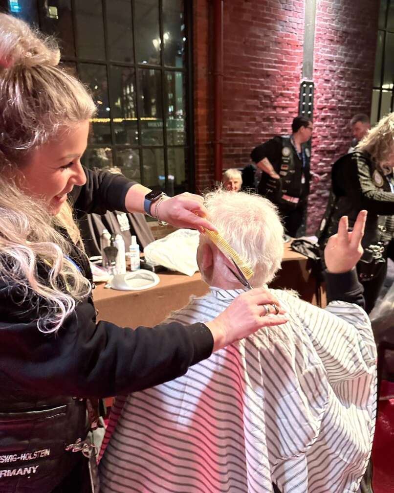 Eine Friseurin schneidet einem Herren die Haare